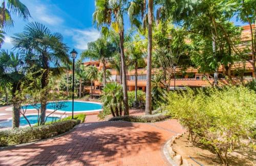 een resort met een zwembad en palmbomen bij Apartamento Milla De Oro Marbella in Marbella