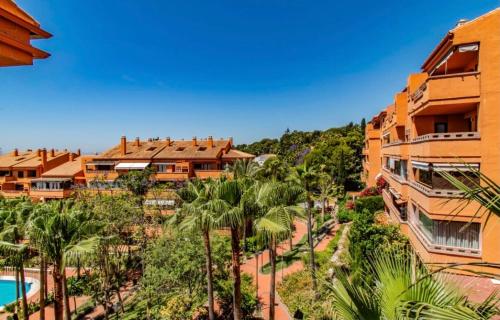 een uitzicht op een resort met palmbomen en een zwembad bij Apartamento Milla De Oro Marbella in Marbella