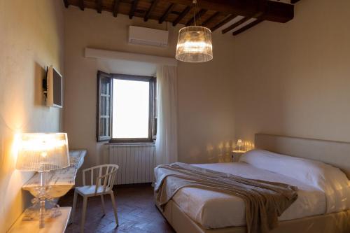 MontemassiにあるTenuta di Montemassi Fattoriaのベッドルーム1室(ベッド1台、テーブル、椅子付)