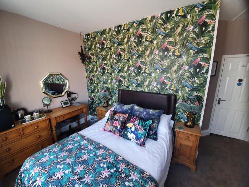 a bedroom with a bed with a floral wallpaper at The Dudley Hotel in Blackpool