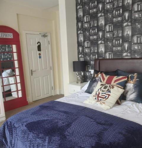 a bedroom with a bed and a red door at The Dudley Hotel in Blackpool