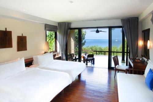two beds in a room with a view of the ocean at Pimalai Resort & Spa in Ko Lanta