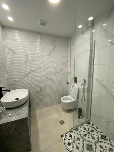 uma casa de banho com um chuveiro, um WC e um lavatório. em Paraskevi's Apartments em Kissamos
