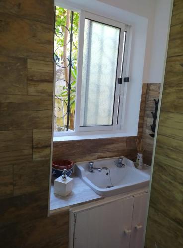 a bathroom with a sink and a window at Casas do Patio sem Cantigas 1 in Sintra