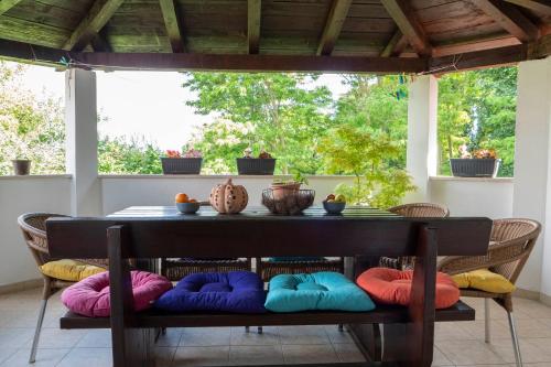 una mesa con almohadas coloridas en el porche en Apartment and Rooms Vilma, en Fažana