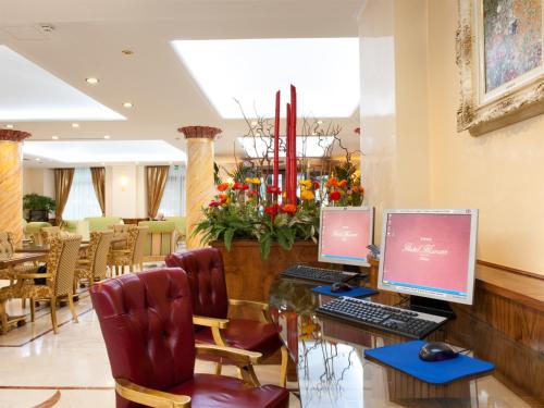 a lobby with two computer monitors on a desk at Hotel Marconi in Milan