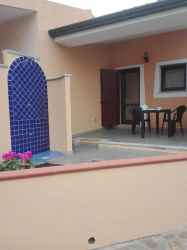 ein Haus mit einem blauen Gitter auf der Seite in der Unterkunft A un passo dal mare Budoni - Matta e Peru in Tanaunella