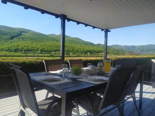a table on a deck with a view of mountains at Vila Gosen in Şard