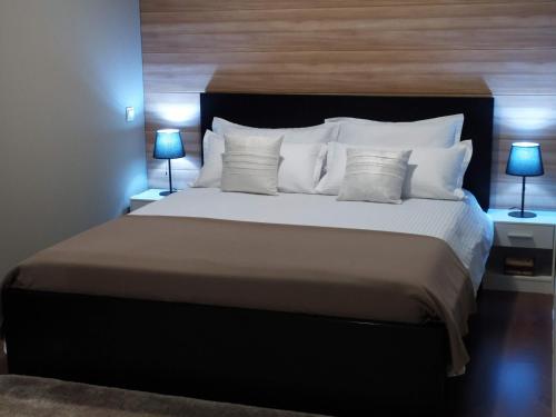 a bedroom with a large bed with white pillows at Vila Gosen in Şard