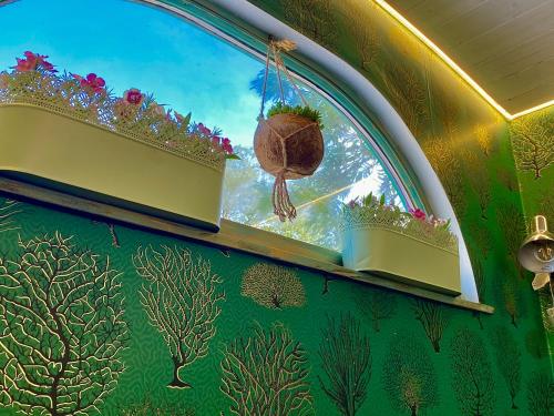 a wall with a window with plants on it at Bohemian Eco Lodge at lake Balaton in Kisapáti