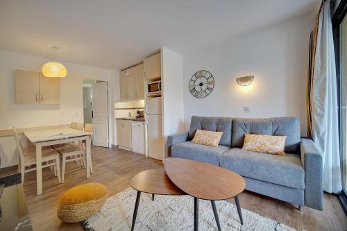 un salon avec un canapé bleu et une table dans l'établissement IMMOGROOM - 3 Rooms - Renovated - Pool - Air conditioning - Parking - Wifi, à Cannes