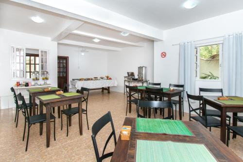 een eetkamer met tafels en stoelen en een keuken bij Pousada Casuarina Ferradura in Búzios