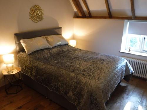 a bedroom with a large bed with two lamps at 2 Vicarage Lane in Highworth