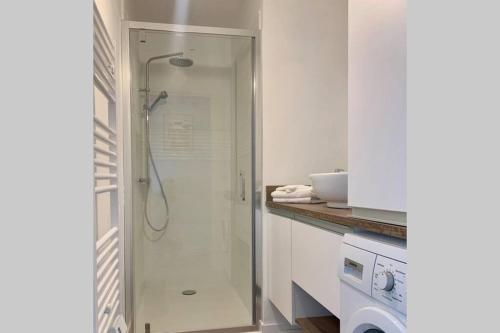 a shower with a glass door in a bathroom at Le Charmant, appartement situé dans la résidence de standing, les Dunes du Golf à Wimereux in Wimereux