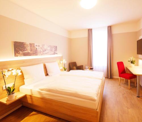 - une chambre avec un lit, un bureau et une table dans l'établissement KELKO 1A Hotel, à Kehl