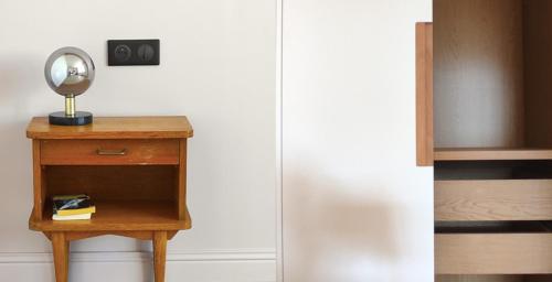 a small wooden table with a mirror on top of it at Appart hôtel & Spa La Villa du Port in Vannes
