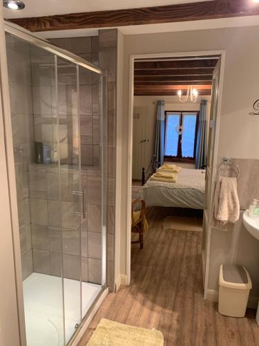a bathroom with a shower and a bedroom with a bed at Countryside B&B in Darnac