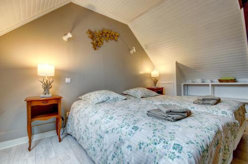 een slaapkamer met een bed, een tafel en lampen bij LES DEUX RIVIERES - Chambres & Table d'Hôtes - in Le Faouët