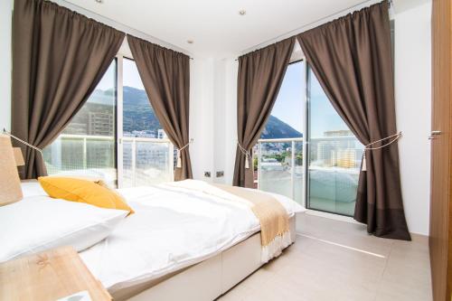1 dormitorio con 1 cama y ventanas grandes en Luxury modern apartment with exceptional views!, en Gibraltar