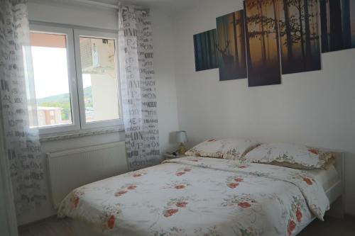 a bedroom with a bed and a window at Apartman Lilly in Modriča