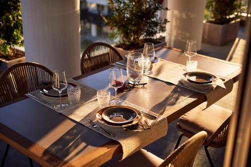 a wooden table with glasses and plates on it at La Furibonda in Fano