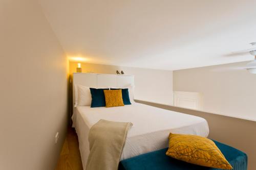 ポルトにあるDK'studioの小さなベッドルーム(白いベッド、青と黄色の枕付)
