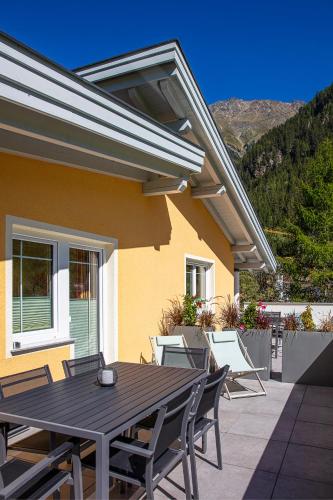 a patio with a wooden table and chairs at Appartement MonAlisa in Sölden