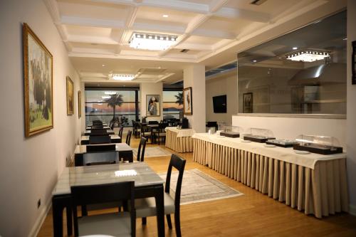restauracja ze stołami i krzesłami w pokoju w obiekcie Hotel IMPERIAL we Wlorze