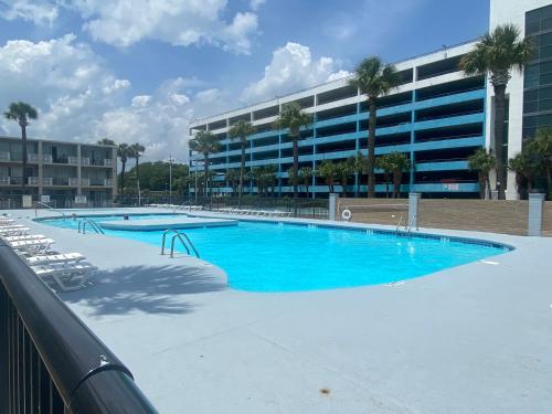 a large swimming pool in front of a building at Wave Rider Resort in Myrtle Beach