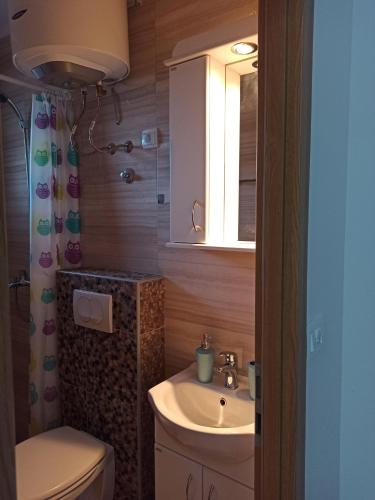 a bathroom with a sink and a toilet and a window at Lastva Holliday Rooms in Budva