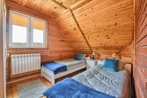a bedroom with two beds in a wooden cabin at W dolinie Sanu in Lesko