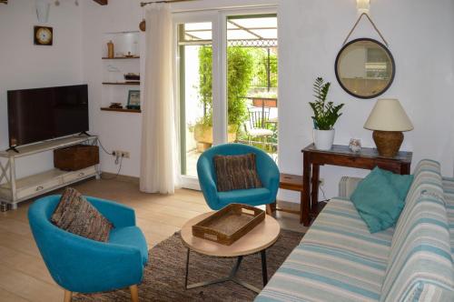 a living room with a couch and chairs and a tv at ISSA Holiday Home - 3 Min Walk to Beach in Kaštela