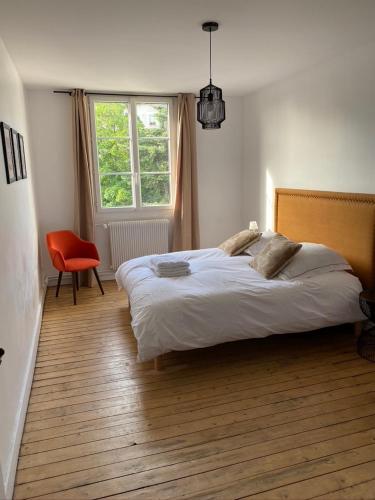 une chambre avec un lit, une chaise et une fenêtre dans l'établissement Quiétude en hyper-centre, à Blois
