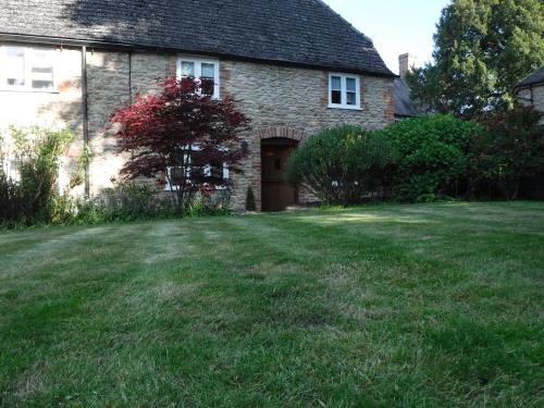a brick house with a large yard in front of it at 2 Vicarage Lane in Highworth