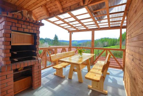 a deck with a brick fireplace and a table and benches at W dolinie Sanu in Lesko