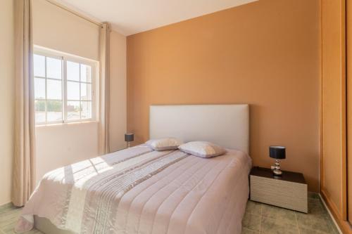 ein Schlafzimmer mit großem Bett und Fenster in der Unterkunft Villa Ribeiro By Keys to Algarve in Armação de Pêra