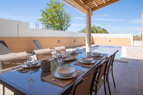 a dining table and chairs on a patio at Villa Ribeiro By Keys to Algarve in Armação de Pêra