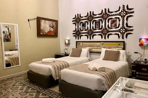 a bedroom with two beds and a mirror at BOCO Boutique Hotel in Cospicua