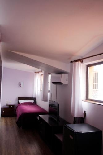 a bedroom with a bed and a window at Guest House Bulgari in Kazanlŭk