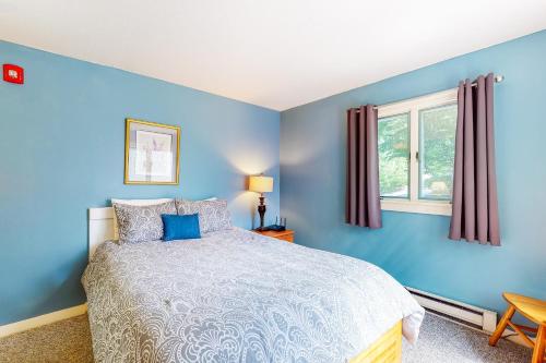 - une chambre bleue avec un lit et une fenêtre dans l'établissement Snowcone, à Bartlett