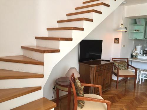 - un salon avec un escalier, une table et des chaises dans l'établissement Apartments Villa Mila, à Cavtat