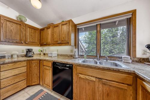 a kitchen with wooden cabinets and a sink and a window at 6 Red Cedar in Sunriver