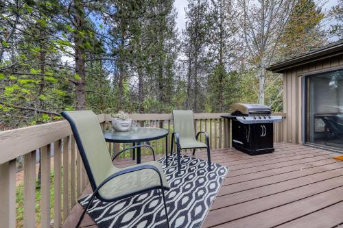 two chairs and a table on a deck with a grill at 6 Red Cedar in Sunriver