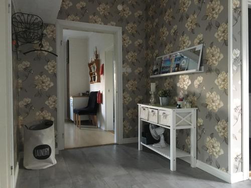 a room with a white table and a wall with flowers at Nebulosavägen 20 in Sundsbruk