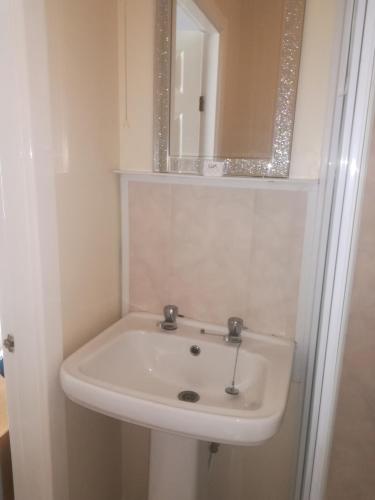 a white sink in a bathroom with a mirror at The Kirkview in Blackpool