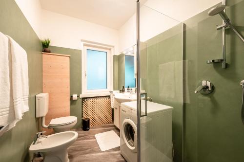 a bathroom with a toilet sink and a washing machine at -Antermoia- Appartament Canazei Center in Canazei