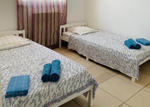 a room with two beds with blue pillows on them at Maison avec vue panoramique in Cavalaire-sur-Mer