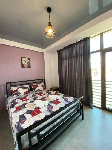 a bedroom with a bed with a quilt on it at Aparthotel Alfa in Ureki