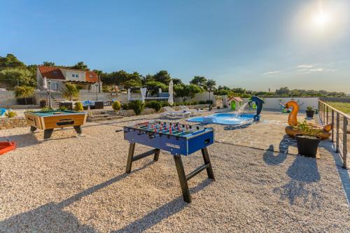 a play table in a backyard with a pool at Villa Mis in Supetar