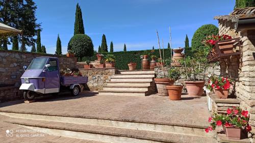 a small purple car parked in a courtyard with flowers at Rocca degli Olivi in San Gimignano